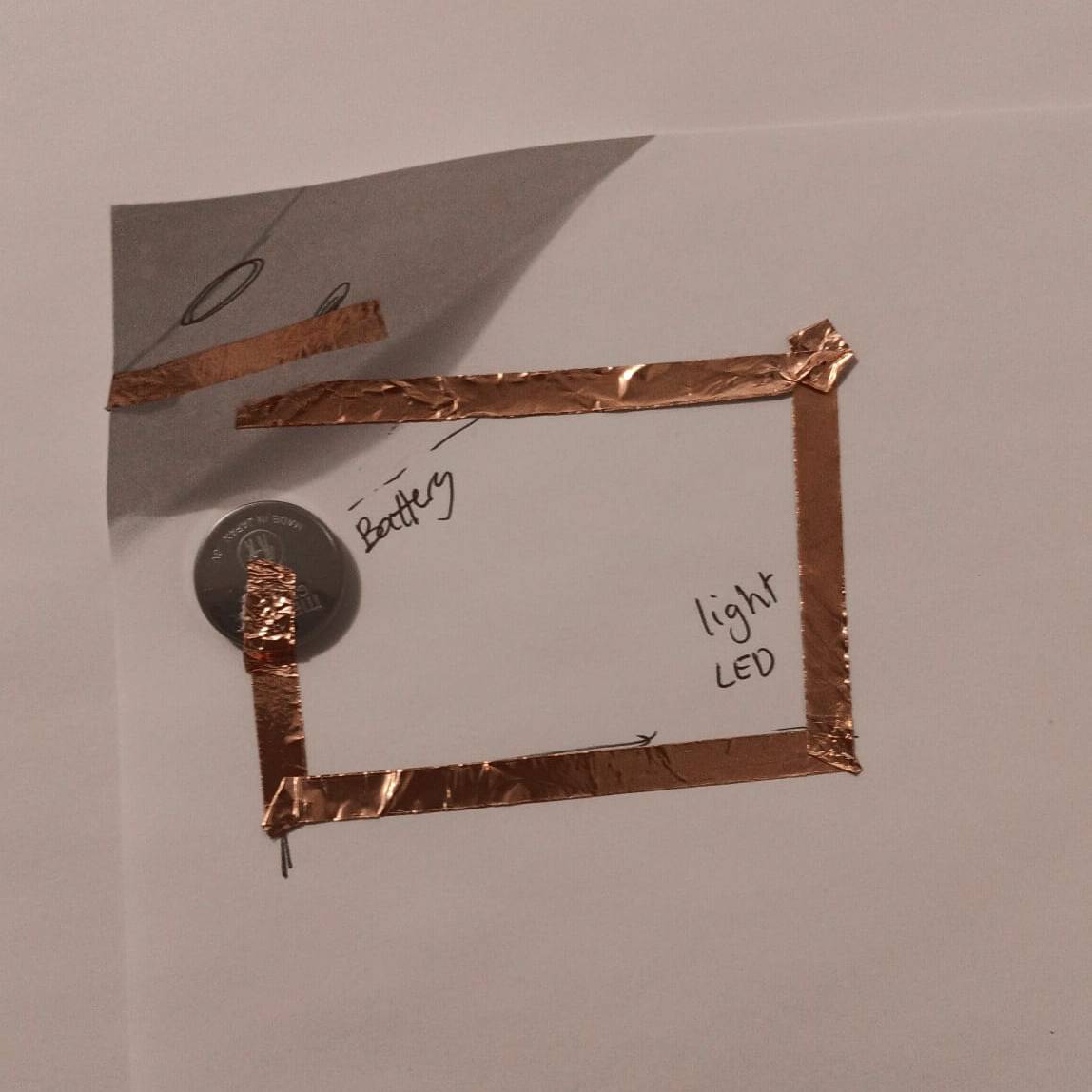 Here I add the switch which is a piece of copper taped to the side of the paper so that it controls when the light will turn on.