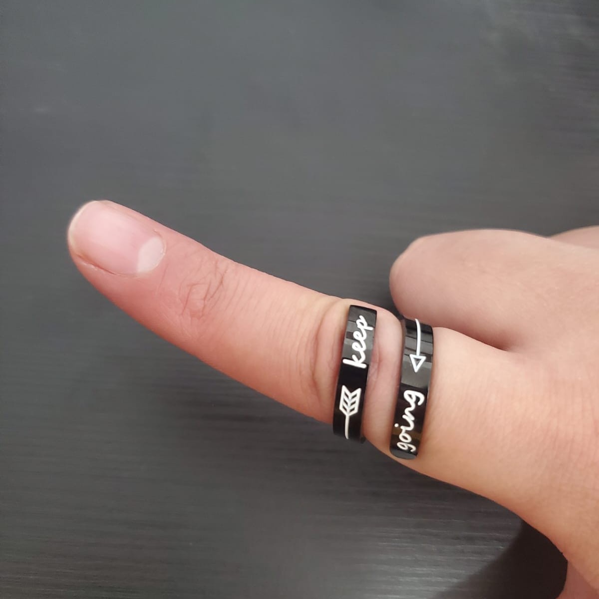 A hand wearing rings, highlighting rotational and tactile interaction with wearable objects.